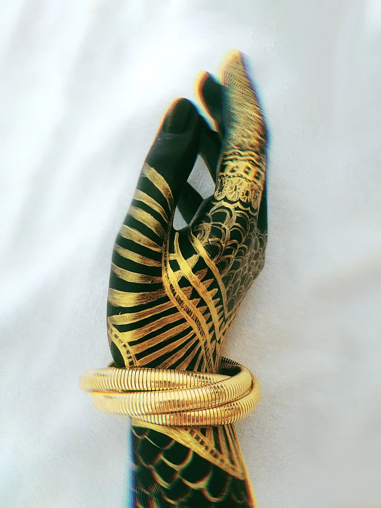 Fairies Whisper Statue of Liberty Bracelet worn on wrist, bold gold coil jewelry inspired by freedom and satire
