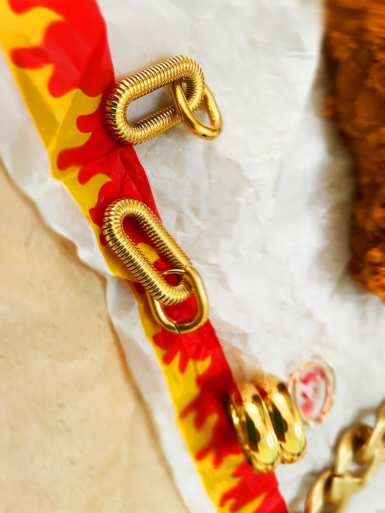 Fairies Whisper Arena Earrings on McDonald’s wrapper, gold rectangular coil spring design industrial jewelry