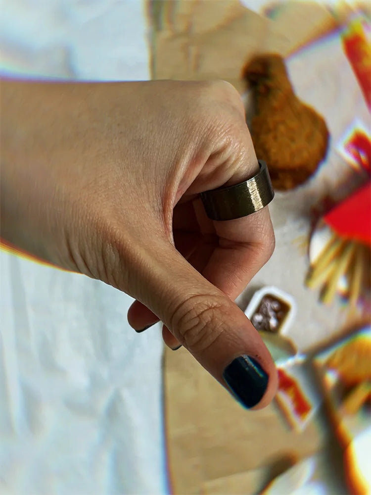 Fairies Whisper Pharaoh Ring worn with McDonald’s scene, thumbs down gesture mocking consumer culture industrial jewelry