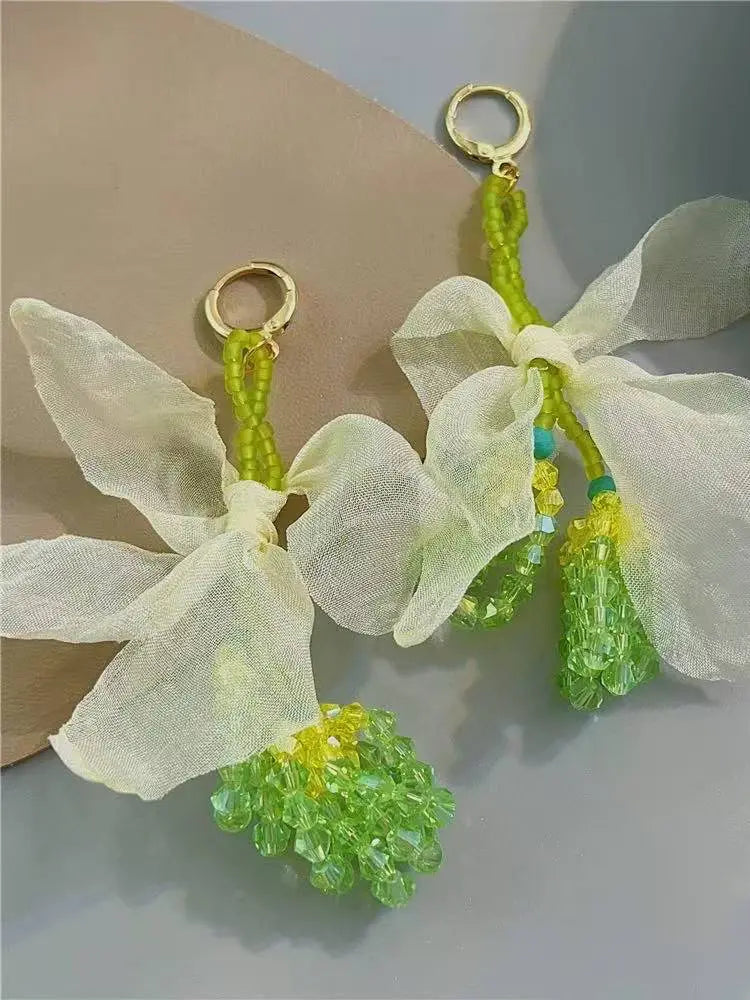 La fée verte tisse des boucles d'oreilles