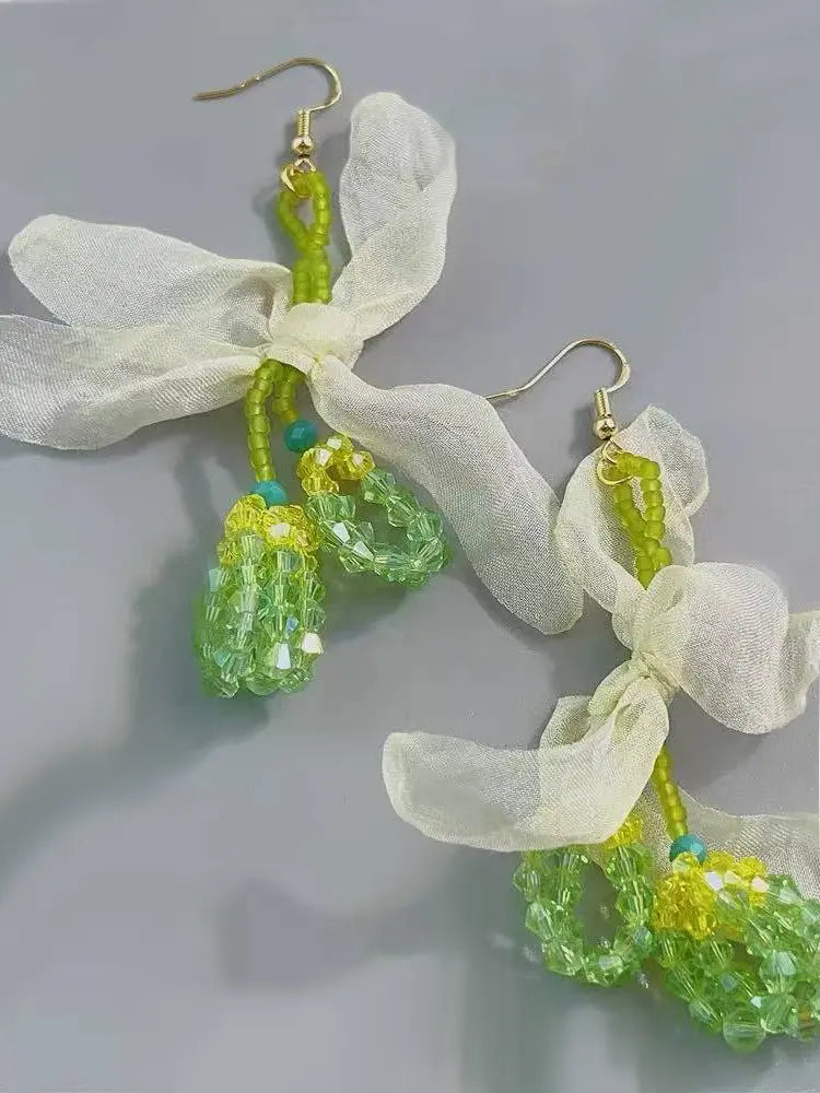 La fée verte tisse des boucles d'oreilles