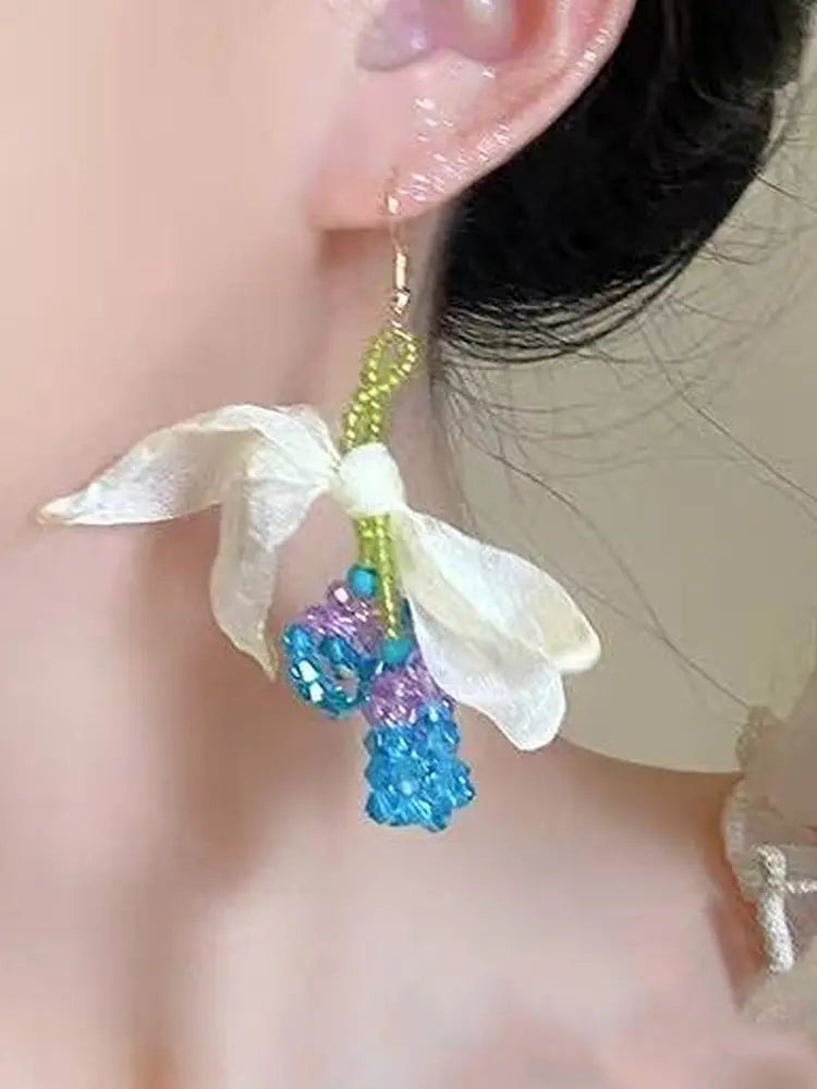 La fée verte tisse des boucles d'oreilles