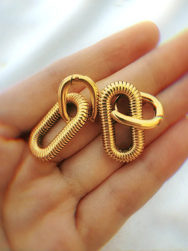 Fairies Whisper Arena Earrings size comparison on hand, gold coil spring arena-inspired jewelry
