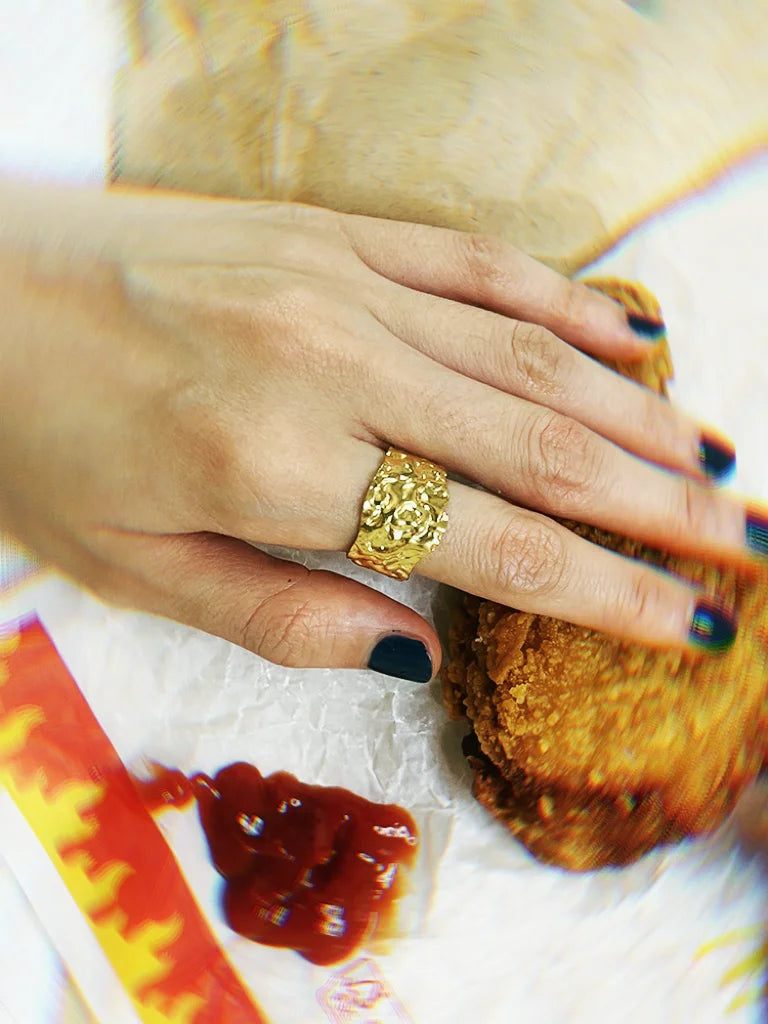 Fairies Whisper Venus de Milo Ring styled with fast food scene, worn on hand holding fried chicken, bold artistic jewelry photo