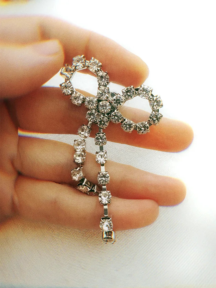 Fairies Whisper Lustre.AI Bow Earrings close-up, silver bow design with sparkling synthetic diamonds